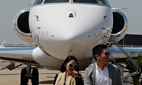 Chinese visitors to a business aviation exhibition walk in front of a private jet
