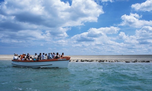 Tourists viewing seals from boat, Blakeney Point, Norfolk.