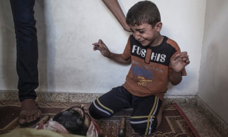 A young Palestinian boy reacts as he sees the body of a relative who died when a UN school used as a shelter for internally displace people came under Israeli shelling in Jabalia, northern Gaza Strip on 30 July 2014.