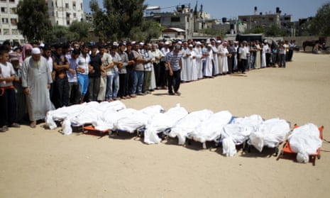 Palestinian mourners pray in front of the bodies of ten members of the al-Astal family, that were killed in an Israeli air strike on their homes, during their funeral in Khan Yunis in the southern Gaza Strip on July 30, 2014.
