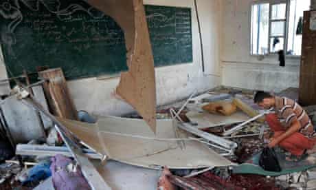 A palestinian collects body parts in a classroom at the Abu Hussein UN school. 