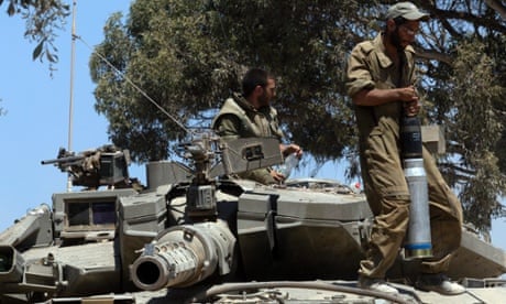 An Israeli soldier carries a tank shell onto a Merkava tank inside southern Israel, close to the Gaza Strip, 31 July 2014.