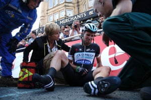 Mark Cavendish of Britain gets assistance after crashing during a mass sprint next to the finish line.