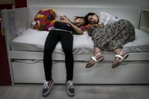 Chinese shoppers sleep on a bed in Ikea in Beijing.