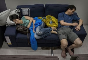 Shoppers sleep on a sofa in the showroom.