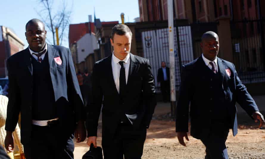 Oscar Pistorius, centre, leaves court escorted by two private security officers in Pretoria, on Monday 7 July, 2014.