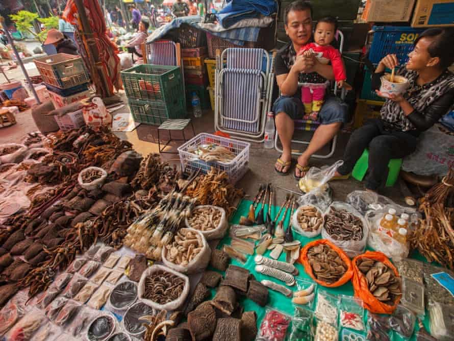 A trader of illegal wildlife products is seen with his family at a covered market in the town of MongLa, Shan State Special Region Four, Burma