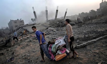 Palestinians salvage their belongings from the rubble of a house destroyed by an overnight Israeli a