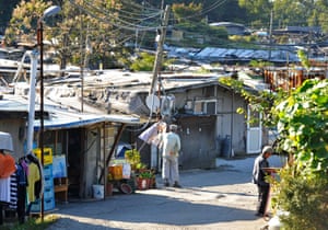 Elderly residents stand outside their homes in Guryong.
