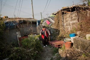 Luo In-soon walks to her Guryong Village home.