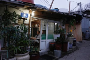 A resident watches a TV in his house in Guryong Village.