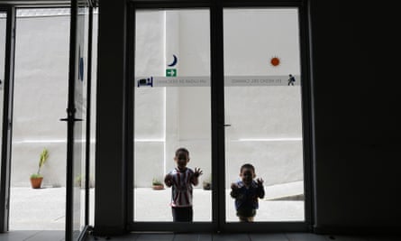 Children play by a window inside a Catholic migrant shelter in San Luis Potosi