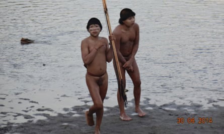 Two members of a previously uncontacted tribe stand on the bank of the Envira river.