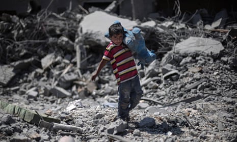 Palestinian boy walks through debris 