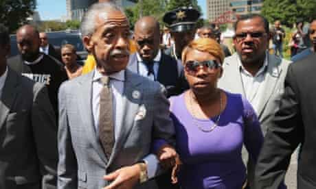 Lesley McSpadden, right, the mother of Michael Brown, arrives for a press conference on the arm of civil rights leader Rev Al Sharpton.