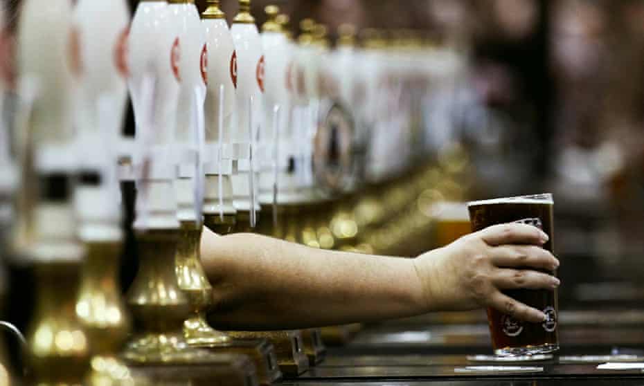 A pint of beer is served through rows of beer pumps