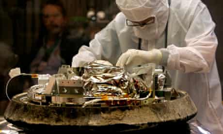 A technician unbolts a canister containing cometary and interstellar dust
