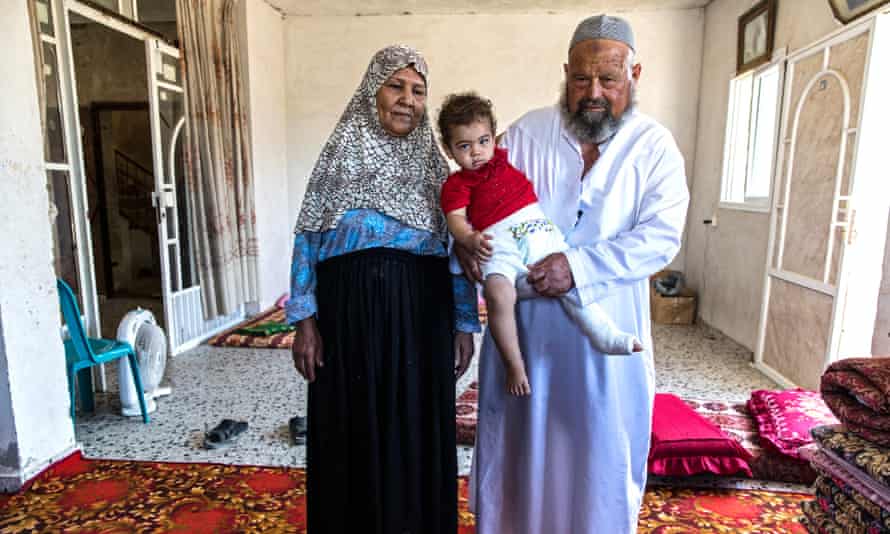 Dalal, left, and Mahrous with their injured 16-month-old granddaughter Mayar in their flat in Rafah. The 67-year-old grandparents are now in effect the child's parents as she lost her mother, father and siblings. Four more members of the family were killed in another air strike the following day.