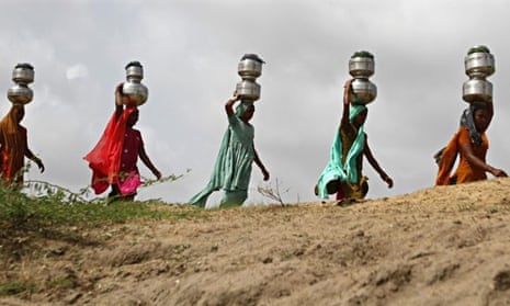 Women walk carrying drinking water India
