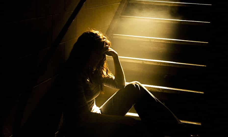 woman in dark at bottom of stairs