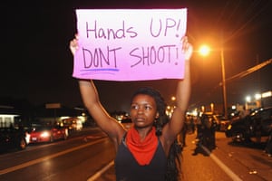 Protestors hold signs during a protest on West Florissant Road in Ferguson, Missouri.
