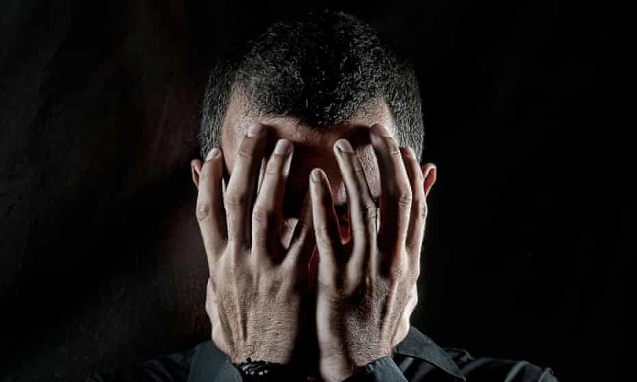 Depressed man with head in hands