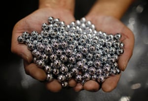 A worker holds silver pachinko balls