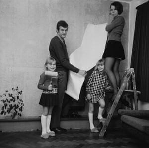 Gordon Bolland of Millwall decorates a room in his house with his wife and children.