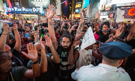 Protesters hold up their arms during a peaceful demonstration in New York City's Times Square on 14 August 2014.