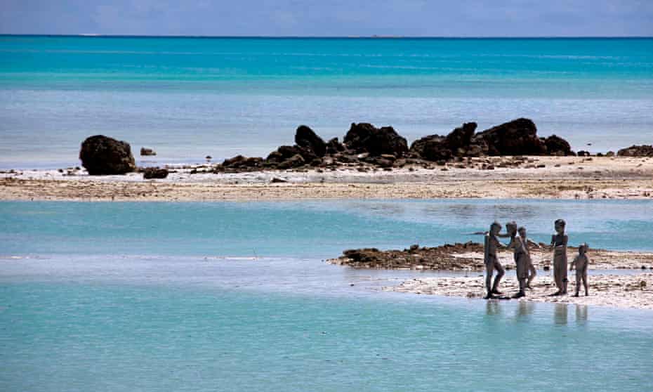 kiribati Young boys cover each other in reef-mud 