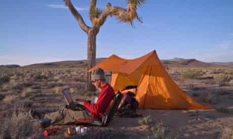 A man working on a laptop while camping in the desert in Death Valley CA