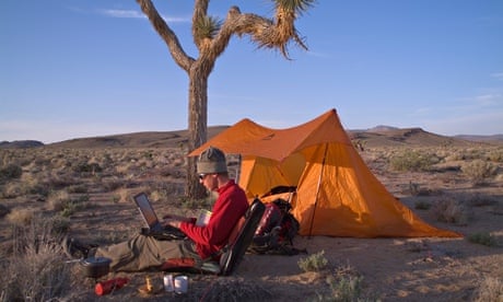 A man working on a laptop while camping in the desert in Death Valley CA