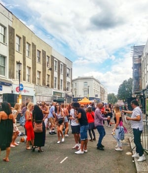 people dancing on a street in west london