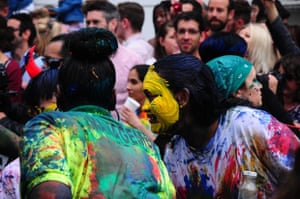 people with paint on their face dancing in the street
