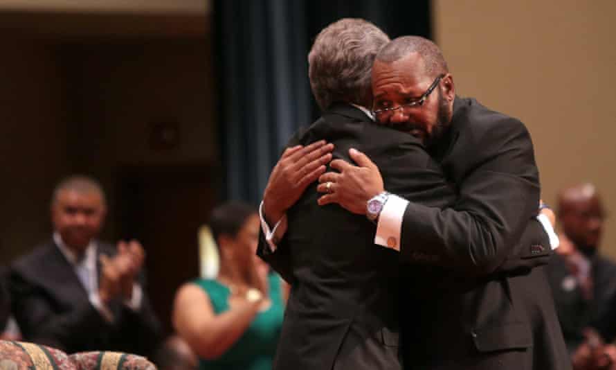 Pastor Charles Ewing (R), the uncle of Michael Brown, embraces Sharpton.