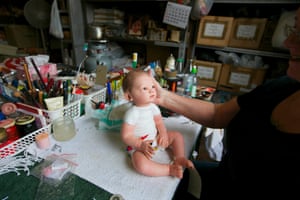 A damaged doll on a workbench after Stuart has finished reattaching its head.