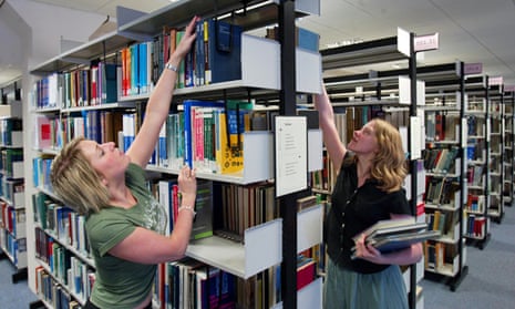 women in library reaching for books