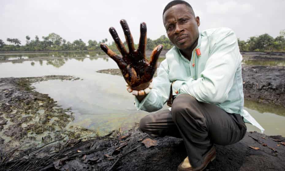 Plaintiff Nigerian farmer Eric Dooh showing his hand covered with oil from a creek near Goi, Ogoniland, Nigeria.