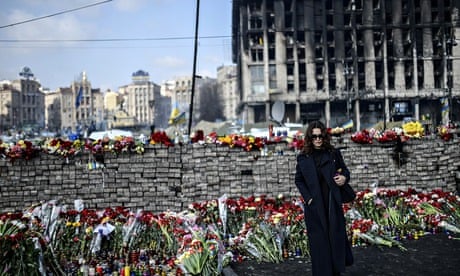 A woman stands near a makeshift memorial in Kiev's Independence Square in February 2014