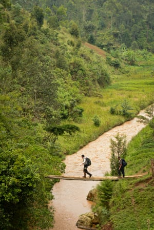 Lev Wood crossing a makeshift bridge over the river Mbriumbe River in Rwanda.