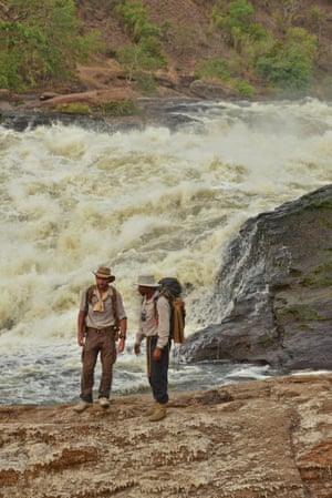 Levison Wood and his guide Boston stand at the top of Murchsion Falls. The River Nile squeezes through a gap of six metres and drops forty metres to create one of the most epic sights on the whole course of the river and is called Murchsion Falls, named after the president of the Royal Geographical Society at the time when Samuel Baker first caught sight of the falls.  Levison is attempting to be the first person to ever walk the enitre length of the Nile. He is 1500km in of a 6500km total journey and started in Rwanda. He is expecitng to finish in Egypt before December 2014. Africa Big Five Lake Albert Lev Wood Levison Wood Murchison Falls National Park River Nile Safari Tom McShane Photography Uganda Uganda Wildlife Authority Walk The Nile Walkiing the Nile Water Waterfall
