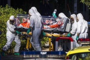 Paramedics wearing protective suits move Miguel Pajares, a Spanish missionary infected with Ebola, on a special isolation stretcher, at Carlos III hospital, in Madrid, Spain