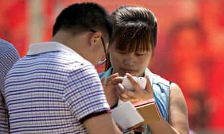 People using their smartphone in Tiananmen Square, Beijing