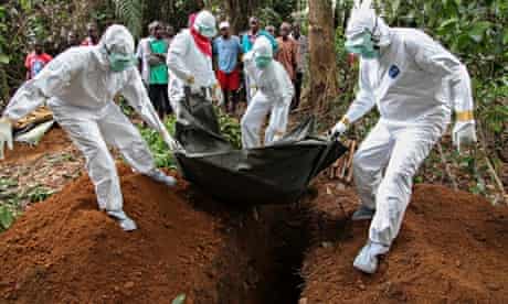 Nurses bury the body of an Ebola victim in Liberia