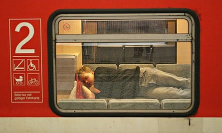 A passenger sleeps in a train stationed at Augsburg's railway station, Germany.