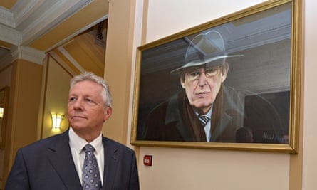 Northern Ireland First Minister Peter Robinson in front of a portrait of Ian Paisley at Stormont 