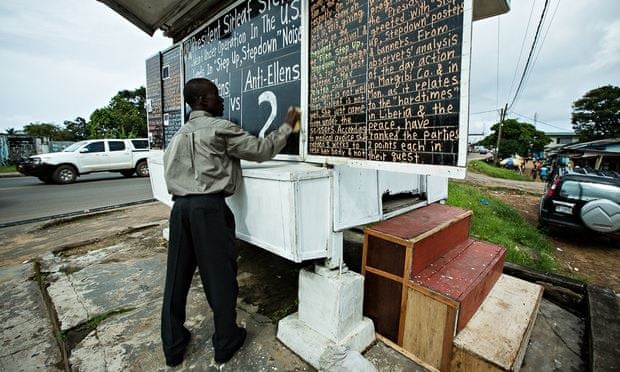 Alfred Sirleaf, a Liberian citizen journalist, with his chalkboard newspaper