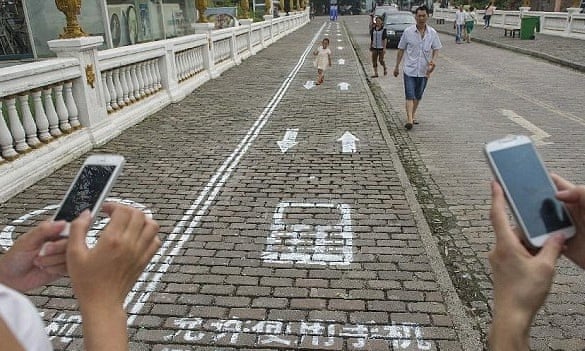 Vía en Chongqing, China, para ir leyendo o escribiendo sobre el smart phone (Fuente: https://i.guim.co.uk/img/static/sys-images/Guardian/Pix/pictures/2014/9/15/1410787901624/85296c07-cb3e-4ed7-9119-fb19f2d04b1b-bestSizeAvailable.jpeg?w=620&q=55&auto=format&usm=12&fit=max&s=904c9e75da40b704373832965b967296)