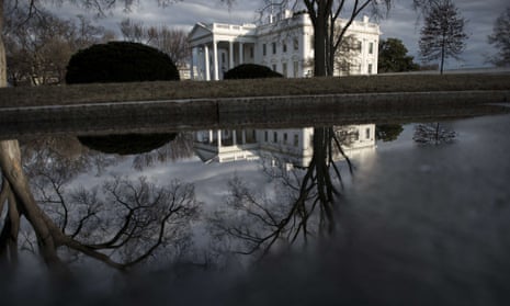 The White House is seen reflected in a puddle in Washington DC