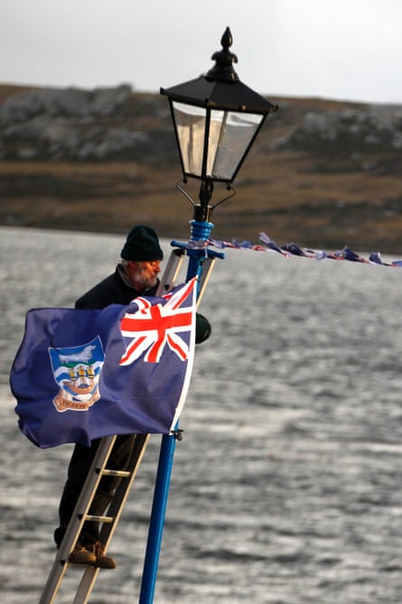 A man hangs a Falklands flag in Stanley to celebrate the 30th anniversary of the 1982 Falklands war.